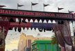 The Universal Orlando Halloween Horror Nights 35 entrance gate features a marquee with the event name, flanked by costumed performers on raised platforms.