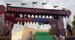 The Universal Orlando Halloween Horror Nights 35 entrance gate features a marquee with the event name, flanked by costumed performers on raised platforms.